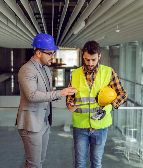 Fachkraft für Arbeitssicherheit berät Bauarbeiter