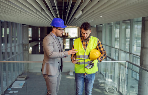 Fachkraft für Arbeitssicherheit berät Bauarbeiter