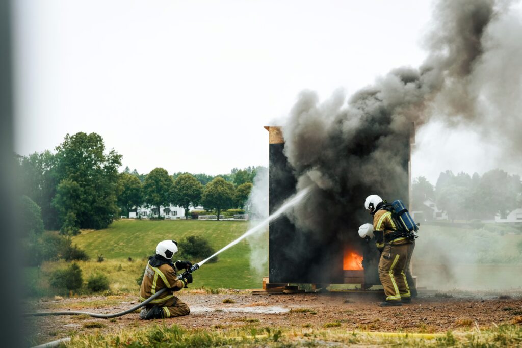Zwei Brandschutzhelfer löschen Feuer